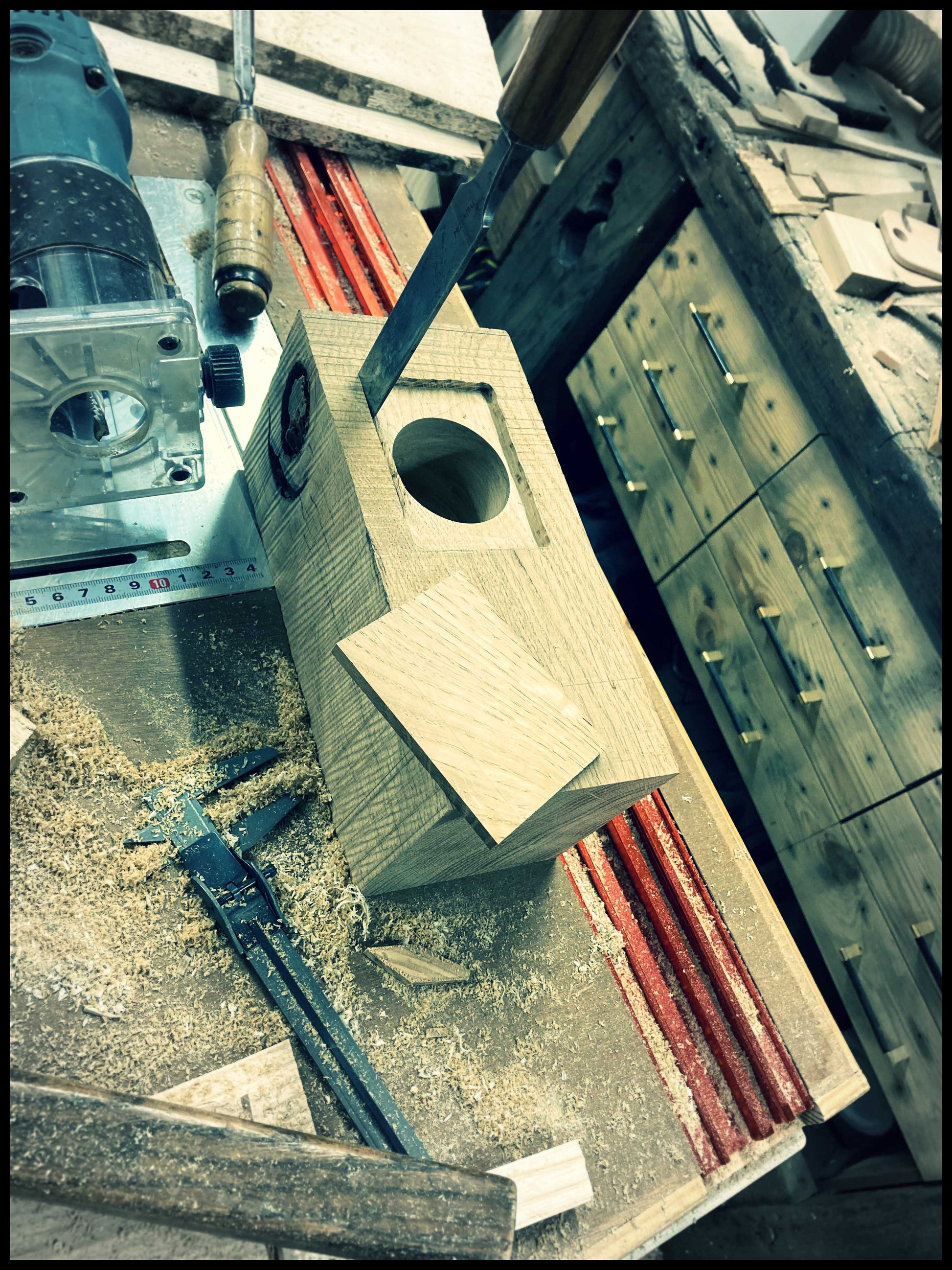 Étape de fabrication d’une lampe Edison en chêne massif dans l’atelier, ajustage au ciseau