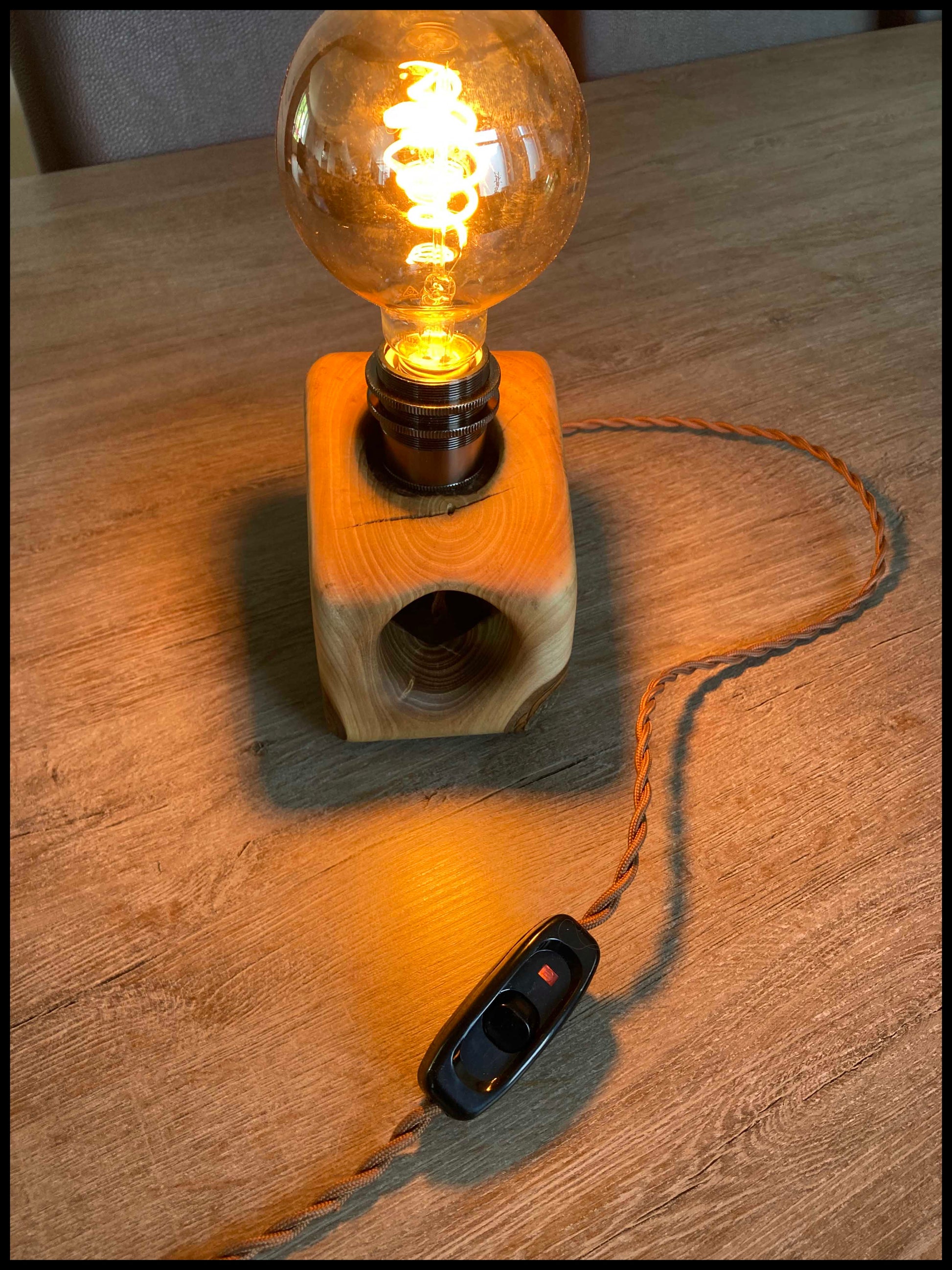 Lampe en noyer massif minimaliste, allumée dans un intérieur contemporain