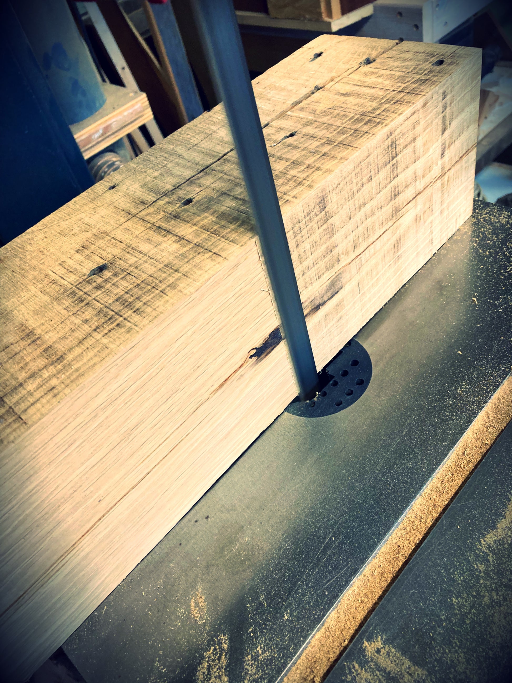 Étape de fabrication d’une lampe en bois massif de chêne avec clés de cytise, le vieillissement à la lame de scie